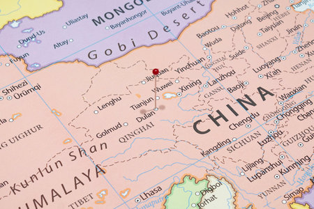 Close up to a Dulan city with a red pin needle into China country political mapの写真素材