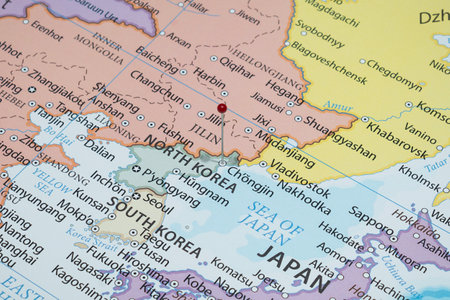 Close up to a Chongjin city with a red pin needle into North Korea country political mapの写真素材
