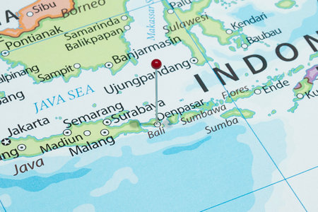 Close up to a Denpasar city with a red pin needle into Indonesia country political mapの写真素材