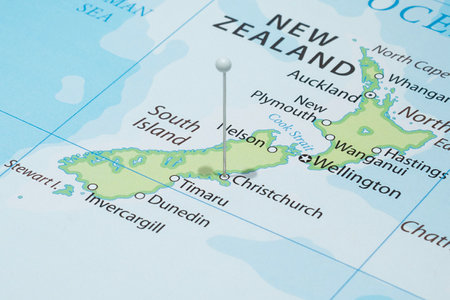 Close up to a Christchurch city with a white pin needle into New Zealand country political mapの写真素材
