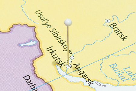 Close up to a Irkutsk city with a white pin needle into Russia country political mapの写真素材
