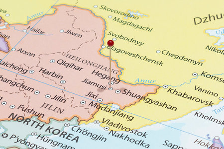 Close up to a Jiamusi city with a red pin needle into China country political mapの写真素材
