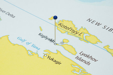Close up to a Kigilyakh city with a blue pin needle into Russia country political mapの写真素材
