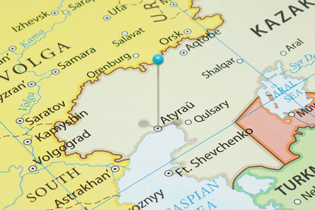 Close up to a Atyrau city with a light blue pin needle into Kazakhstan country political mapの写真素材
