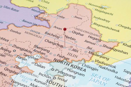 Close up to a Changchun city with a red pin needle into China country political mapの写真素材