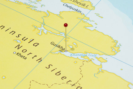 Close up to a Gusikha city with a red pin needle into Russia country political mapの写真素材