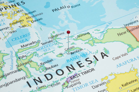 Close up to a Ambon city with a red pin needle into Indonesia country political mapの写真素材