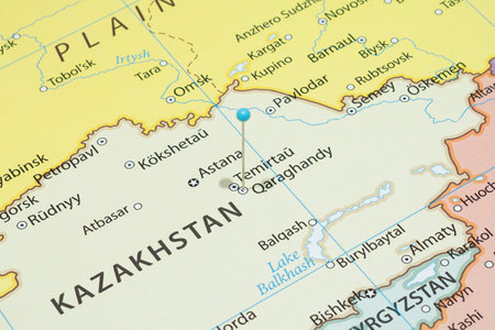 Close up to a Karagandy city with a light blue pin needle into Kazakhstan country political mapの写真素材
