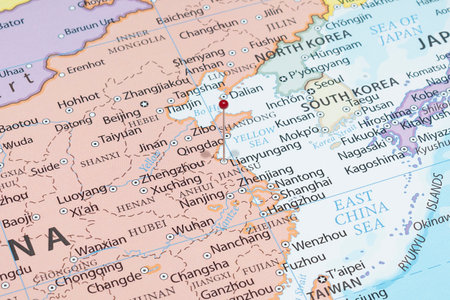 Close up to a Lianyungang city with a red pin needle into China country political mapの写真素材