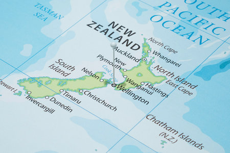 Close up to a Wellington city with a white pin needle into New Zealand country political mapの写真素材