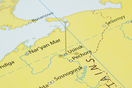 Close up to a Usinsk city with a white pin needle into Russia country political mapの写真素材