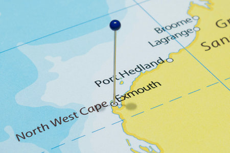 Close up to an Exmouth city with a blue pin needle into Australia country political mapの写真素材