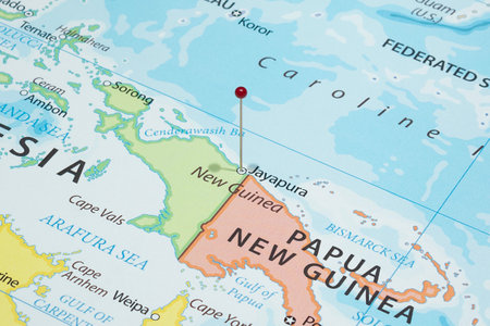 Close up to a Jayapura city with a red pin needle into Indonesia country political mapの写真素材