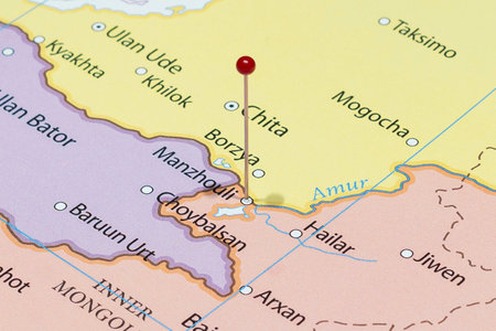 Close up to a Manzhouli city with a red pin needle into China country political mapの写真素材