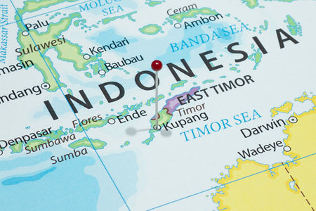 Close up to a Kupang city with a red pin needle into Indonesia country political mapの写真素材