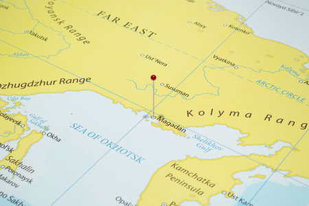Close up to a Magadan city with a red pin needle into Russia country political mapの写真素材