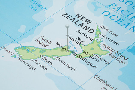 Close up to a Nelson city with a white pin needle into New Zealand country political mapの写真素材