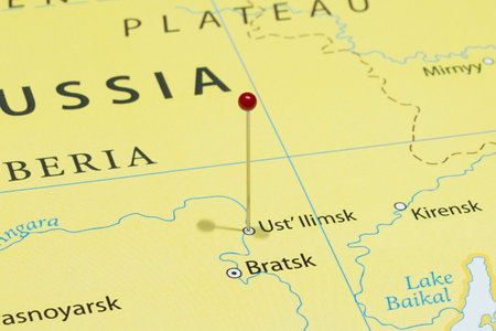 Close up to a Ust Ilimsk city with a red pin needle into Russia country political mapの写真素材