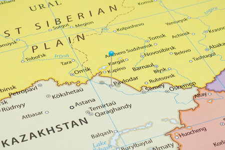 Close up to a Pavlodar city with a light blue pin needle into Kazakhstan country political mapの写真素材