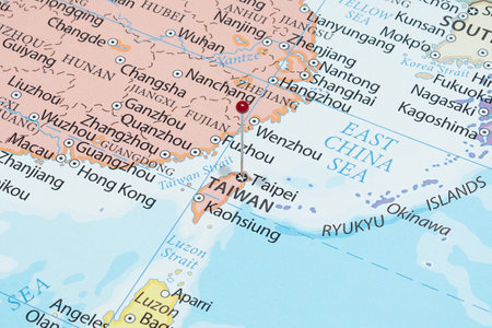 Close up to a Taipei city with a red pin needle into Taiwan country political mapの写真素材