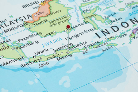 Close up to a Surabaya city with a red pin needle into Indonesia country political mapの写真素材