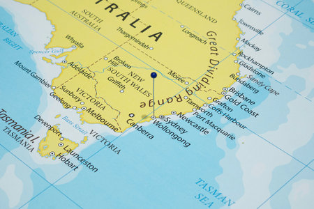 Close up to a Wollongong city with a blue pin needle into Australia country political mapの写真素材