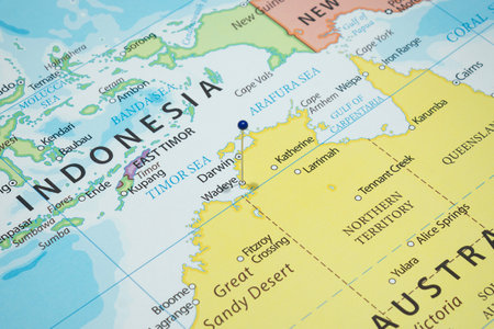 Close up to a Wadeye city with a blue pin needle into Australia country political mapの写真素材