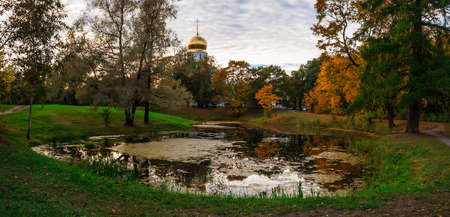 Panoramic autumn landscape with a pond and the churchの写真素材