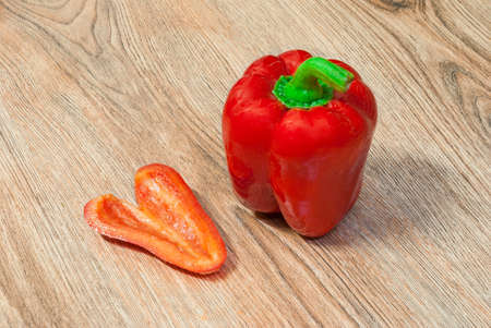 Pepper and its heart shaped slice on a wooden backgroundの写真素材