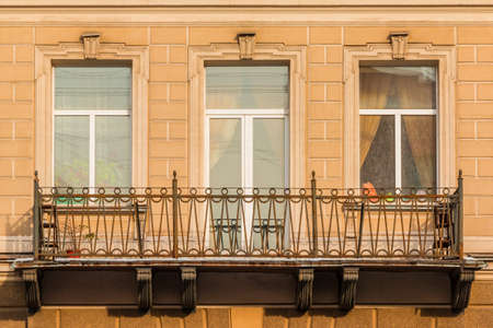 Two windows and door in a row and balcony on facade of urban apartment building front view, St. Petersburg, Russiaの写真素材