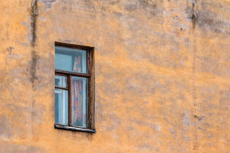 Single window on brown crumbling facadeの写真素材