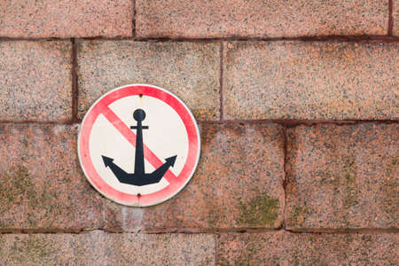 Prohibiting sign "Do not throw anchors" on granite wall of embankmentの写真素材