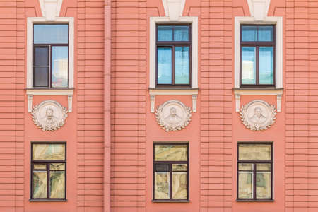 Several windows in row on facade of urban apartment building front view, St. Petersburg, Russiaの写真素材