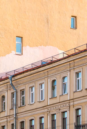 Facades of two separate apartment buildings with different number of windows, St. Petersburg, Russiaの写真素材
