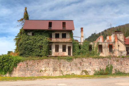 Wall of dilapidated Abaata fortress with abandoned houses over it in Gagra, Abkhazia, HDR processingの写真素材