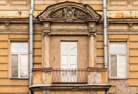 Three windows in a row nd balcony on facade of urban apartment building front view, St. Petersburg, Russiaの写真素材