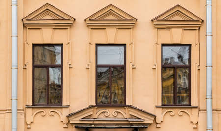 Three windows in a row on facade of urban apartment building front view, St. Petersburg, Russiaの写真素材