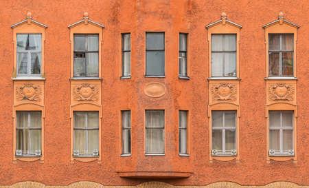 Several windows in a row and bay window on facade of urban apartment building front view, St. Petersburg, Russiaの写真素材