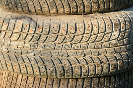 A stack of old tires with textured tread on sunlight closeupの写真素材