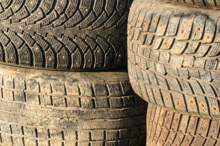 A stack of old tires with textured tread on sunlight closeupの写真素材