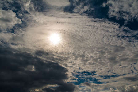 Sun hidden behind a veil of cloudsの写真素材