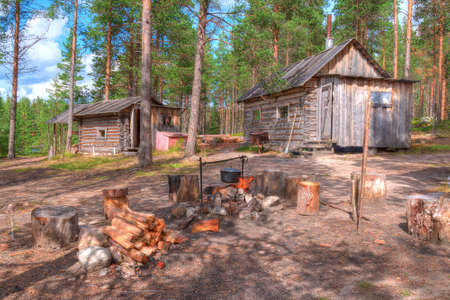 Campfire on a background of the hut and a banya in the forestの写真素材