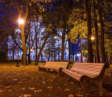 Night autumn view of illuminated St. Nicholas Naval Cathedral and benches in Nikolskiy garden, St. Petersburg, Russiaの写真素材