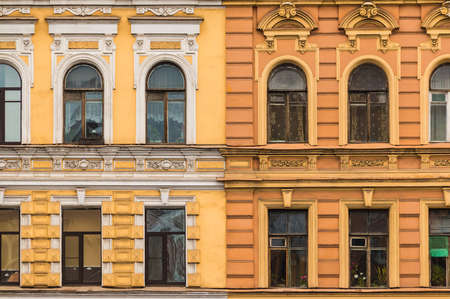 Several windows in a row on facades of two different apartment buildings adjacent tightly to each...
