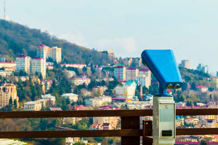Binoculars on viewing platform on the background of mountain with buildings, Sochi, Russiaの写真素材