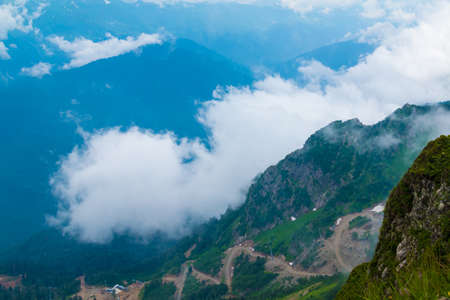 Aerial view of mountains, clouds and valley from the top of mountain in Rosa Khutor, Russia