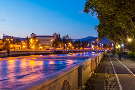 Night view of illuminated Kubanskiy bridge and embankment of Sochi river, Sochi, Russiaの写真素材