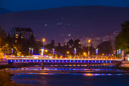 Night view of illuminated Kubanskiy bridge and Sochi river on the background of mountain, Sochi, Russiaの写真素材