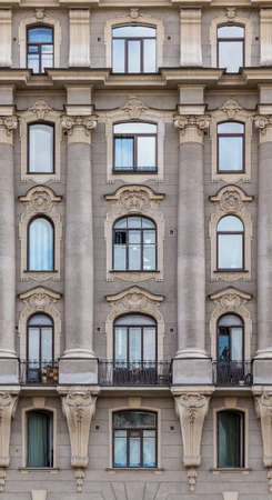 Several windows in a row and balcony on facade of urban apartment building front view, St. Petersburg, Russiaの写真素材