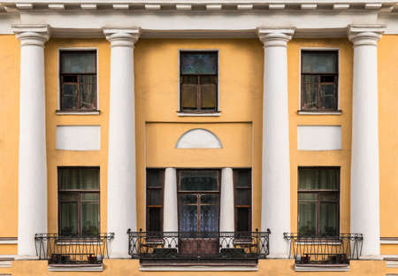 Several windows, columns and balconies in a row on facade of urban apartment building front view, St. Petersburg, Russiaの写真素材